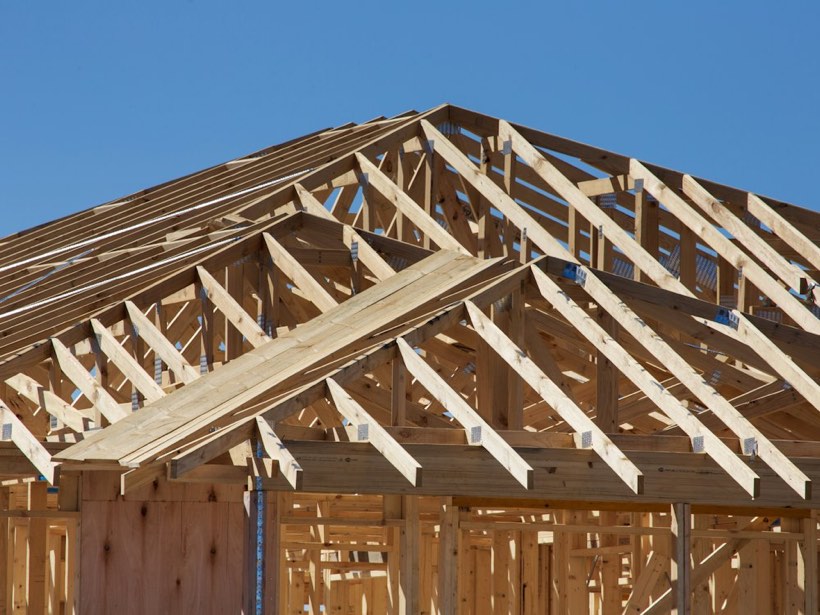 Neuer Dachstuhl aus Holz vor blauem Himmel während der Bauphase