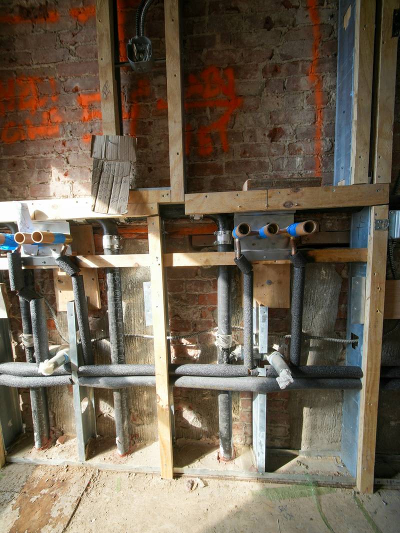 Vorher: entkerntes Bad mit offenen Wänden und neuen Wasser- und Abwasserleitungen im Rohbau