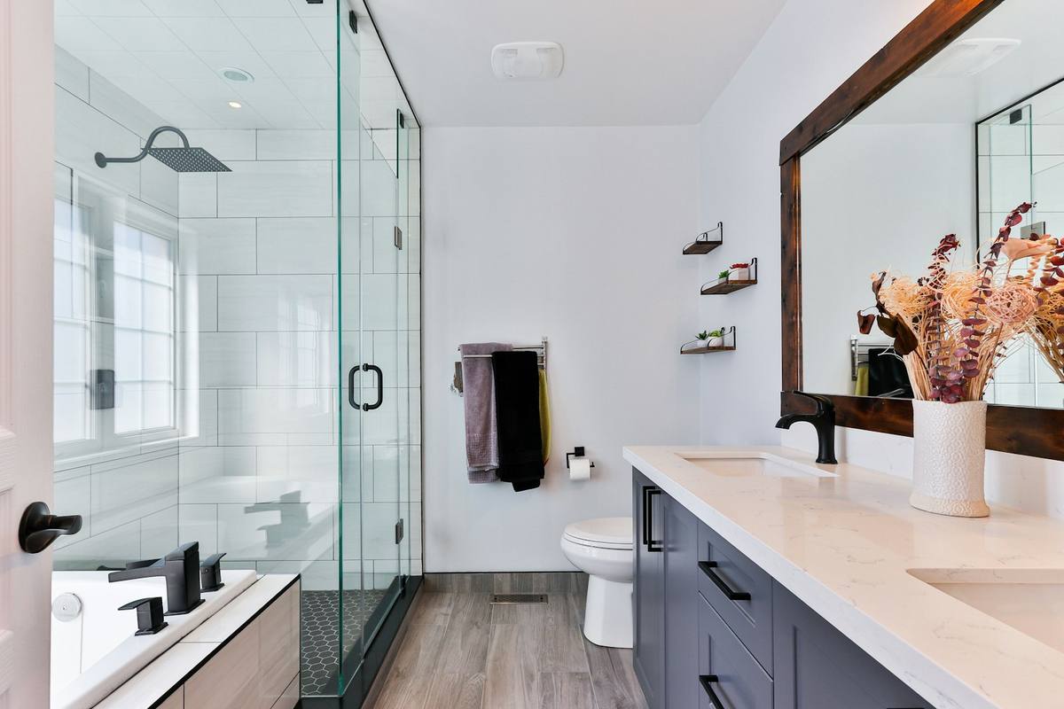 Modernes Duschbad mit Glasabtrennung, Regendusche und langem Waschtisch